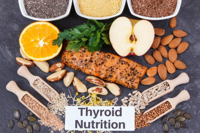 A flat lay of nutrient-dense foods supporting thyroid health, including salmon, Brazil nuts, seeds, and leafy greens, labeled “Thyroid Nutrition.”